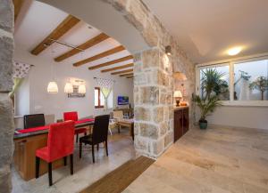 a dining room with a stone wall and a table and chairs at Holiday Home Pitve in Pitve