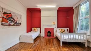 a red room with two beds and a fireplace at Sleeps 20 Stunning Ashton Mansion in Ashton under Lyne