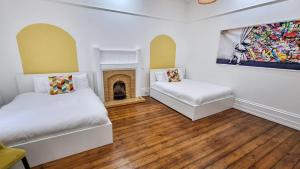 a bedroom with two beds and a fireplace at Sleeps 20 Stunning Ashton Mansion in Ashton under Lyne