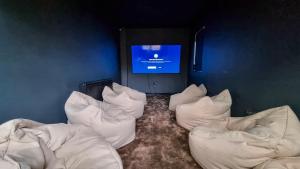 a room with white pillows and a tv on a wall at Sleeps 20 Stunning Ashton Mansion in Ashton under Lyne