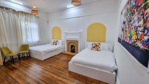 a bedroom with two beds and a fireplace at Sleeps 20 Stunning Ashton Mansion in Ashton under Lyne