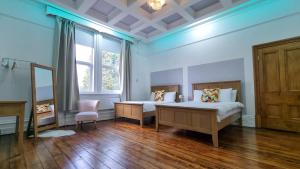 a bedroom with two beds and a window at Sleeps 20 Stunning Ashton Mansion in Ashton under Lyne +23 photos