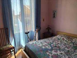 een slaapkamer met een bed en een groot raam bij Casa Vacanze Relax Etna in San Giovanni la Punta