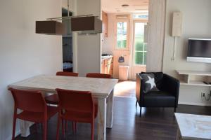 a kitchen and dining room with a table and chairs at 2-person bungalow Heuveltjes in Voorthuizen