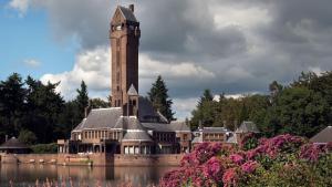 a building with a clock tower in the middle of a lake at 2-person bungalow Heuveltjes in Voorthuizen