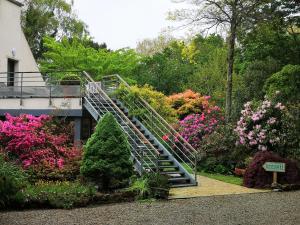 uma escadaria num jardim com flores e árvores em La Canopée des Pins em Cléder
