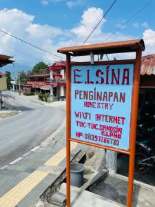 a sign sitting on the side of a street at Elsina guest house in Tuk Tuk