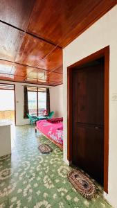 a bedroom with a bed and a door in a room at Elsina guest house in Tuktuk Siadong