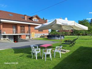 une table, des chaises et un parasol dans l'herbe dans l'établissement Casa Matilde, à Leinì