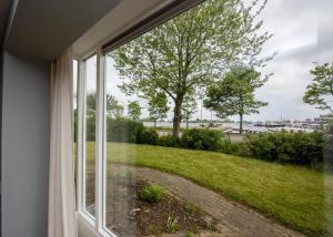 uma janela com vista para um pátio verde em Holidayhouse Bongel 1 Ter Herne em Terherne