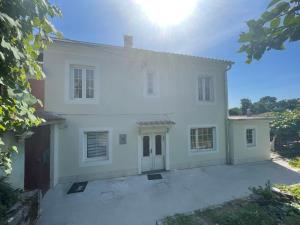 Une grande maison blanche avec le soleil au ciel dans l'établissement Hiša Tartinijeva, à Izola