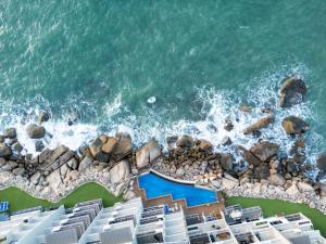 an aerial view of a beach with chairs and the ocean at Grand Mercure Apartments Magnetic Island in Nelly Bay