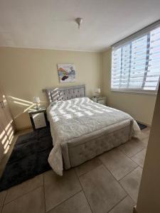 a bedroom with a large bed and a large window at Alojamiento en linares in Linares