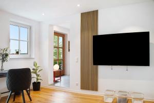 a living room with a flat screen tv on a wall at Schönauer Hof - Wohnung Rosalie in Passau