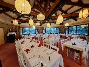a dining room with white tables and chairs and chandeliers at Hôtel Espace Montclar in Montclar