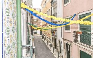 Une ruelle étroite avec des flûtes colorées suspendues aux bâtiments dans l'établissement MY LX FLAT Stylish Apartment in Santa Catarina, à Lisbonne