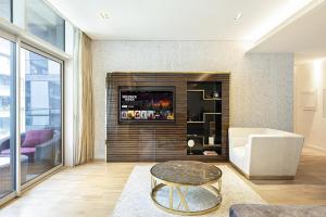 a living room with a tv on a wall at Infinity Holiday Homes - Spacious 2-BR Apt plus Maid's Room in City Walk in Dubai