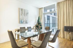 a dining room with a glass table and a christmas tree at Infinity Holiday Homes - Spacious 2-BR Apt plus Maid's Room in City Walk in Dubai