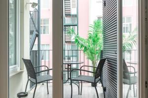 d'un balcon avec des chaises et une table avec une plante. dans l'établissement MY LX FLAT City Center El Corte Inglês, à Lisbonne