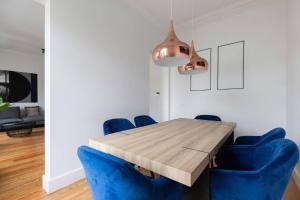 une salle à manger avec une table en bois et des chaises bleues dans l'établissement MY LX FLAT City Center El Corte Inglês, à Lisbonne