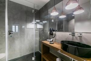 ein Bad mit einem schwarzen Waschbecken und einer Dusche in der Unterkunft MY LX FLAT Bairro Alto Design Apartments in Lissabon