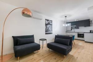 Bairro Alto Design Apartment في لشبونة: غرفة معيشة مع كرسيين وطاولة
