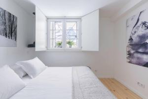 biała sypialnia z łóżkiem i oknem w obiekcie Bairro Alto Design Apartment w Lizbonie