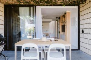 11 Holiday Homes في سان ميغيل ذي أبونا: طاولة غرفة الطعام مع كراسي بيضاء حولها