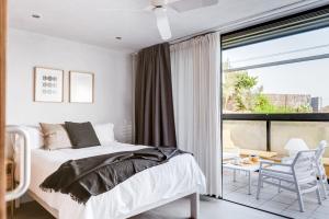 a white bedroom with a bed and a balcony at 11 Holiday Homes in San Miguel de Abona
