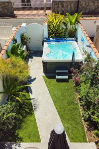 un patio trasero con bañera de hidromasaje en un jardín en BeachClub Mediterran Garden en Mogán