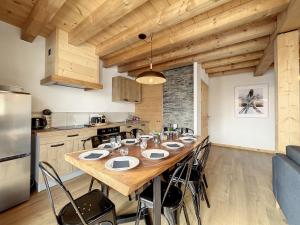 a kitchen with a long wooden table in a room at Chalet Le Charbonnel in La Toussuire