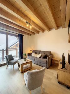 a living room with a couch and a table at Chalet L'Argentière in La Toussuire