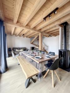 a dining room with a large wooden table and chairs at Chalet L'Argentière in La Toussuire