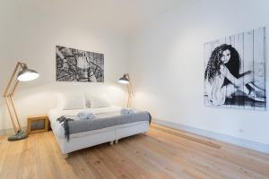 um quarto com uma cama e duas pinturas na parede em MY LX FLAT Baixa Alfama Apartments em Lisboa