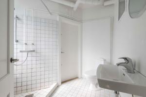 Baño blanco con aseo y lavamanos en Lovely Flat in Vibrant Area, en Copenhague