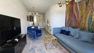 sala de estar con sofá azul y TV en BeachClub Mediterran Garden en Mogán
