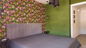 a bedroom with a bed with a flower wall at BeachClub Mediterran Garden in Mogán +13 photos