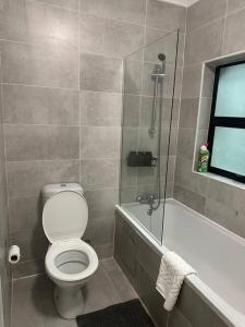 a bathroom with a toilet and a tub and a shower at Kastina Suites in Gaborone