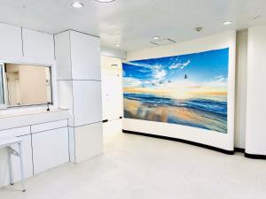 eine Küche mit einem Wandbild des Ozeans in der Unterkunft One Style in Naha