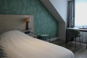 1 dormitorio con cama y pared verde en Het Wapen van Harmelen, en Harmelen