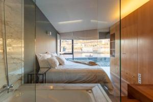 una camera con letto, vasca e finestra di MY DOURO VIEW Luxury Apartment River Front a Vila Nova de Gaia