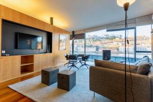 un soggiorno con divano e TV a schermo piatto di MY DOURO VIEW Luxury Apartment River Front a Vila Nova de Gaia