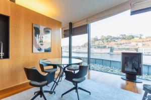 una sala da pranzo con tavolo e sedie e una grande finestra di MY DOURO VIEW Luxury Apartment River Front a Vila Nova de Gaia