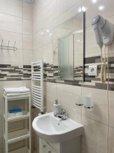 a white bathroom with a sink and a mirror at Bukszpan in Sasino