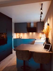 a kitchen with blue cabinets and a table with a laptop on it at House in Ballstad in Lofoten in Skotnes