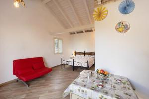 a living room with a red chair and a table at Studio TIMO in Pompeiana