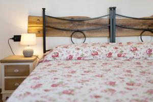 a bed with a red floral bedspread and a lamp at Studio TIMO in Pompeiana
