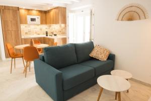 ein Wohnzimmer mit einem blauen Sofa und einem Tisch in der Unterkunft Torre Solana 41 in Cádiz