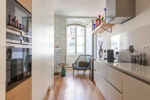 una cocina con armarios blancos y una silla azul en MY LX FLAT Luxury Chiado Design Apartment en Lisboa