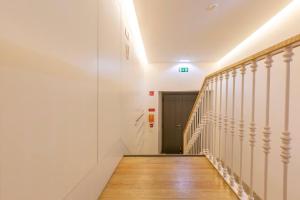 korytarz z białymi ścianami, drewnianymi podłogami i drzwiami w obiekcie MY LX FLAT Luxury Chiado Design Apartment w Lizbonie